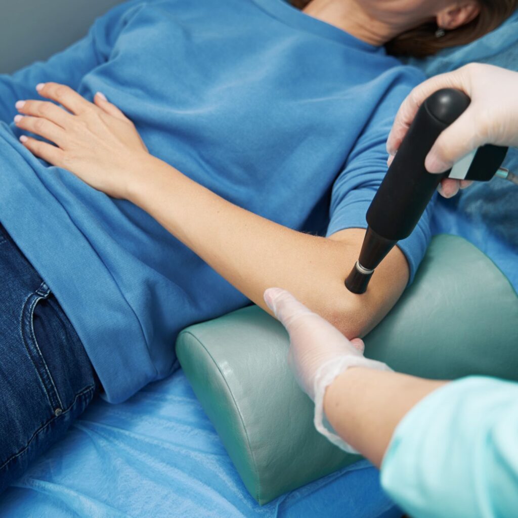 Physiotherapist applying radial shockwave therapy to a patient's elbow at Lake Country Physiotherapy in Orillia